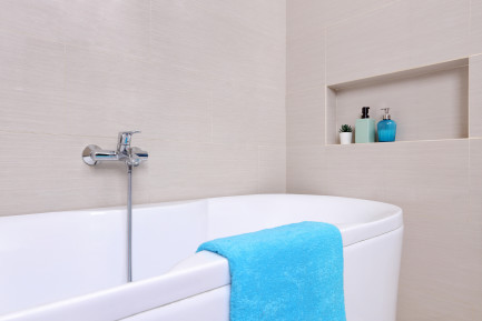A clean bathroom with a blue bathmat